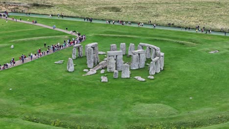Stonehenge-UNESCO-World-Heritage-Site,-Aerial-View-of-Tourist-Crowd-in-Front-of-Ancient-Landmark-60fps