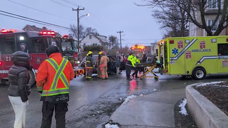 Montrealer-Rettungskräfte-Besuchen-Die-Szene-Eines-Autounfalls,-Während-Rettungssanitäter-Eine-Bahre-Laden