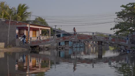 A-mother-carries-her-baby-over-the-bridge-in-a-low-income-neighborhood