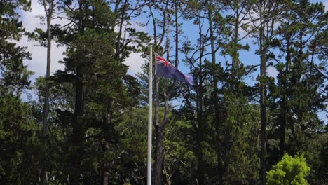 Bandera-De-Nueva-Zelanda-Ondeada-Por-El-Viento-Subtropical,-Verde-Parque-De-Cornualles-En-Auckland