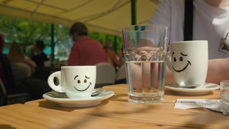 Alegres-Tazas-De-Café-Con-Un-Vaso-De-Agua-Clara-Sobre-Una-Mesa-De-Café