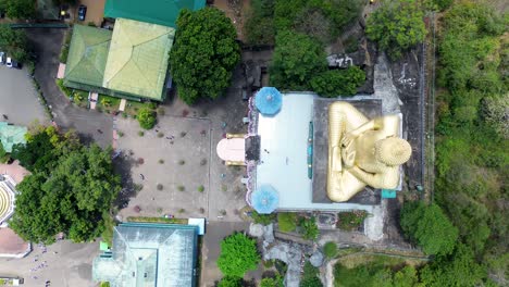 Vista-Aérea-Por-Drones-Del-Templo-Dorado-De-Dambulla-Con-La-Gigantesca-Estatua-Budista-Sagrada-De-Buda-Edificio-Del-Templo-Real-En-Sri-Lanka-Religión-Espiritualidad-Viajes