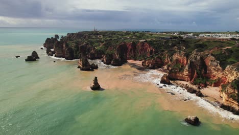 Praia-Dona-Ana-colorful-turquoise-coastline-near-Lagos-in-the-Algarve-region-of-Portugal-by-Aerial-4k-drone-establishing-shot