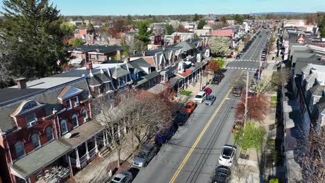 Aerial-establishing-shot-of-red-row-homes-on-urban-city-corner-intersection