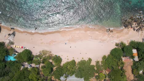 Overhead-drone-flight-over-sandy-beach-in-tropical-setting