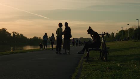 Sunset-at-Jarun-Lake,-Zagreb,-with-people-and-cyclists-enjoying-the-evening