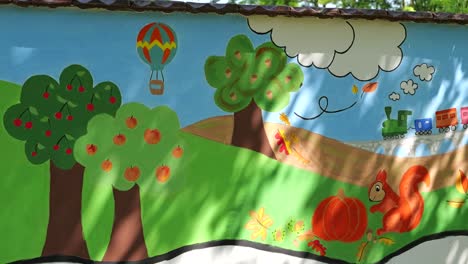 Childlike-painting-showing-cheerful-spring-scene-on-side-of-kindergarten-building-wall