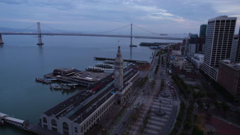 San-Francisco,-Kalifornien,-USA,-Luftaufnahme-Des-Fährgebäudes,-Des-Verkehrs-Am-Embarcadero,-Der-Pfeiler-Und-Der-Oakland-Bridge-In-Der-Dämmerung