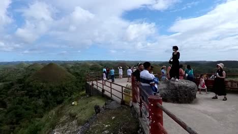 Capture-the-iconic-view-from-the-Chocolate-Hills-viewpoint-in-Bohol,-Philippines,-as-tourists-snap-this-unforgettable-landscape