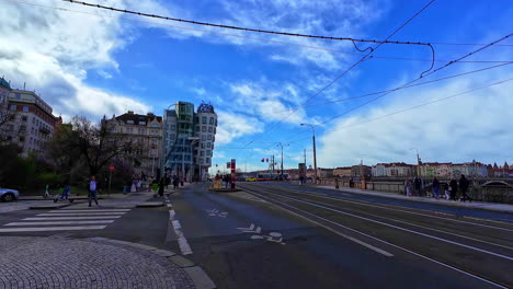 Slow-motion-shot-of-locals-walking-in-front-of-architectural-landmark-dancing-house-aka-Fred-and-Ginger-in-Prague,-Czech-Republic-at-daytime