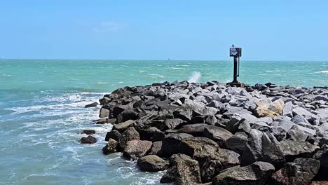 Vista-Estática-De-Las-Olas-Rompiendo-En-La-Pared-De-Roca-Cerca-De-Beach-Post-En-Cocoa-Beach,-Florida