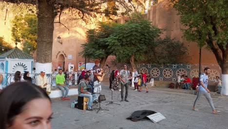 Street-musicians-practice-before-the-performance-amongst-awaiting-local-people-and-tourists-in-the-central-square-of-Chefchaouen,-Morocco