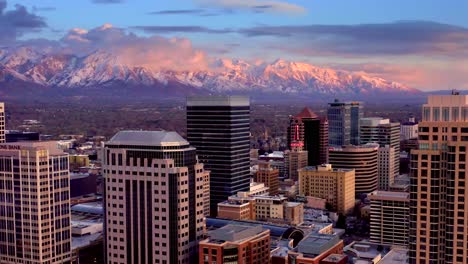 Luftaufnahme-Der-Skyline-Von-Salt-Lake-City,-Sonnenuntergangsansicht,-Leuchtende-Skyline-Von-Salt-Lake-City,-4K-Drohnenaufnahme-Mit-Dem-Wasatch-Mountain-Im-Hintergrund