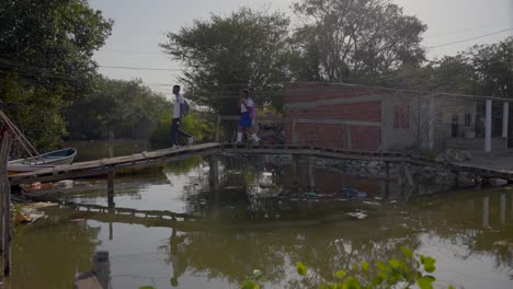 Una-Niña-Y-Un-Niño-Con-Uniforme-Escolar-Cruzan-Un-Puente-En-Un-Barrio-Pobre