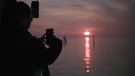 Silueta-Capturando-En-Un-Teléfono-La-Serena-Puesta-De-Sol-De-Burano,-Venecia