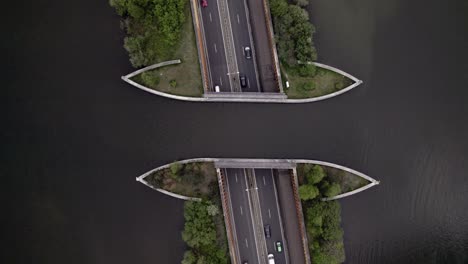 Antena-Fija-De-Arriba-Hacia-Abajo-Que-Muestra-La-Autopista-Con-El-Tráfico-Pasando-Por-Debajo-Del-Acueducto-De-Veluwemeer-Visto-Desde-Arriba