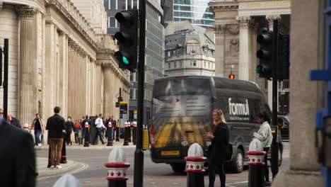 Escena-Dinámica-De-Una-Calle-Diurna-En-Bank-Junction,-Cerca-Del-Banco-De-Inglaterra-En-Londres,-Que-Muestra-Un-Vibrante-Movimiento-Peatonal,-Un-Bullicioso-Transporte-Público-Y-Un-Tráfico-Fluido.