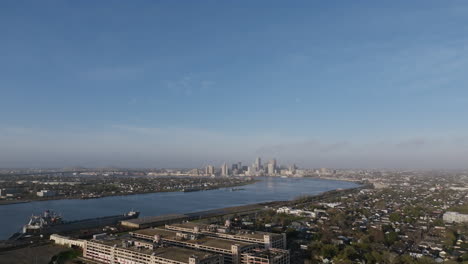 Aerial-flyover-of-a-neighborhood-outside-of-New-Orleans-revealing-the-Mississippi-River-and-downtown-in-the-background