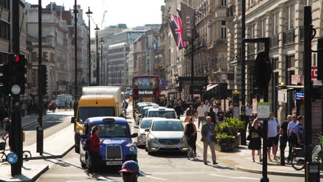 Static-view-of-the-bustling-London-streetscape-at-an-intersection-during-daylight-hours,-showcasing-various-modes-of-transportation-and-the-vibrant-activity-of-people
