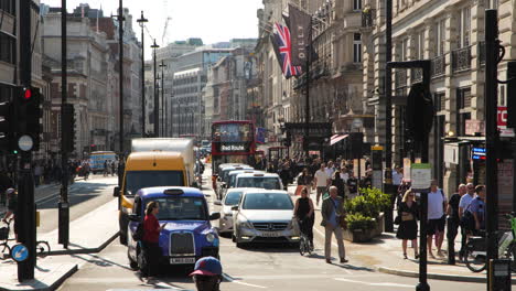 Vista-Estática-Del-Bullicioso-Paisaje-Urbano-De-Londres-En-Una-Intersección-Durante-Las-Horas-Del-Día,-Mostrando-Varios-Modos-De-Transporte-Y-La-Vibrante-Actividad-De-La-Gente.