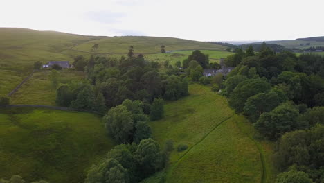 Drone-flies-over-farmland-in-Northumberland,-England-at-sunset