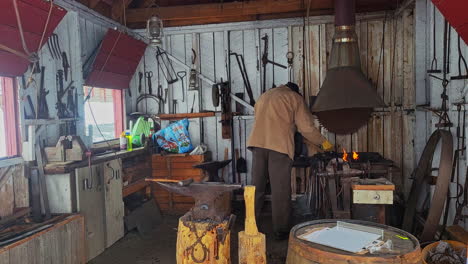 Wide-Shot-of-a-Man-Forging-Metal-at-a-Forge