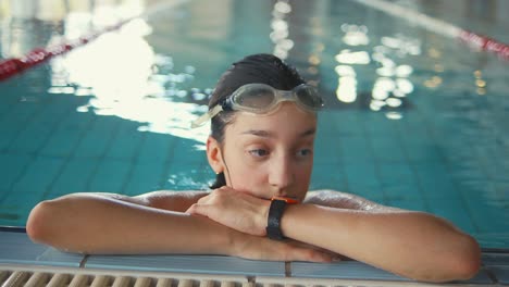 A-young-woman-is-seen-in-a-pool,-relaxing-after-a-swim