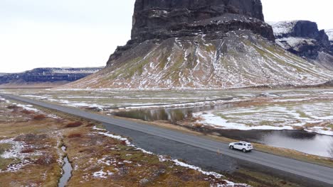 Asphalted-Highway,-Cars-Drive-at-Mountain-Volcanic-Landcape-in-Iceland,-Skyline