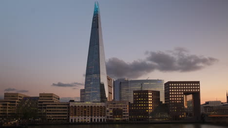 Hermosa-Transición-Del-Día-A-La-Noche-Del-Edificio-Shard-En-Londres,-Con-Hermosos-Reflejos-De-Luz-De-La-Ciudad