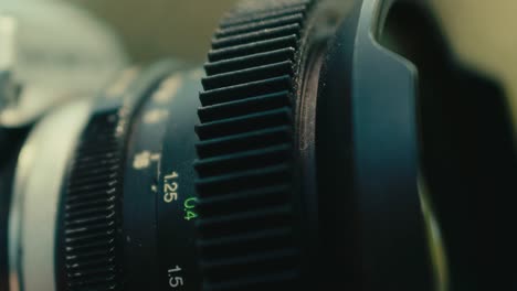 female-hand-close-up-while-turning-the-focus-wheel-on-old-fashioned-vintage-retro-film-camera-lens