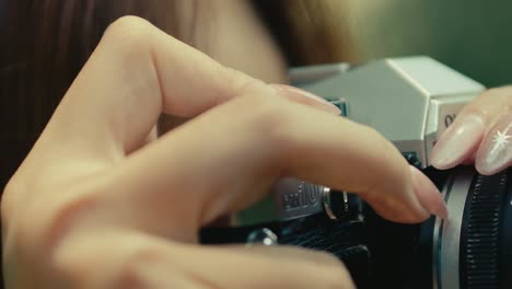 close-up-of-female-hand-with-long-nails-pressing-the-shutter-button-on-old-vintage-retro-camera-film
