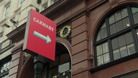 Sign-pointing-to-Carnaby-Street,-Soho,-London,-Day