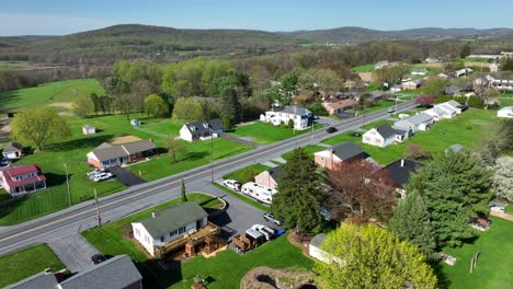 Tráfico-En-La-Intersección-Rural-En-Un-Paisaje-Escénico-Con-Casas-Y-Hogares