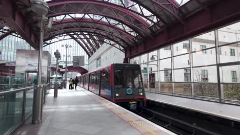 DLR-Train-Approaching-Canary-Wharf-Station-With-Commuters-Waiting-On-Platform