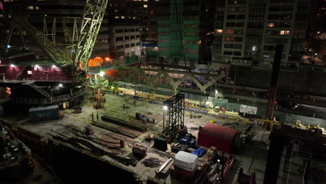 Aerial-view-away-from-a-floating-construction-site-in-Lenox-Hill,-night-in-New-York