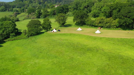 Vuelo-Aéreo-Sobre-Las-Copas-De-Los-árboles-Grandes-Robles-Glamping-Día-Soleado-Reino-Unido-4k