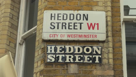 Close-of-Heddon-Street-road-sign-in-old-and-new-styles,-London,-Day