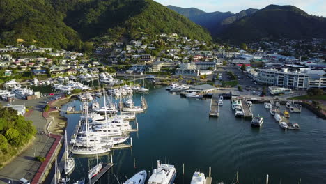 Drone-shot-of-marina-at-Picton-Harbour,-South-Island,-New-Zealand-at-sunset