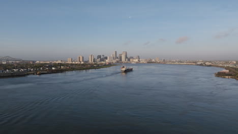 Breite-Luftaufnahmen-Von-Einem-Großen-Containerschiff-Auf-Dem-Mississippi-River-Mit-Der-Innenstadt-Von-New-Orleans-Im-Hintergrund-Am-Morgen