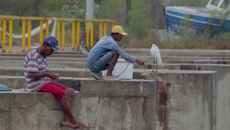 Two-fishermen-on-a-bridge-patiently-wait-for-the-catch-of-the-day