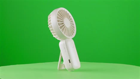 Turn-on-Handy-fan-electric-hand-mobile-ventilator-handyfan-portable-heat-hot-in-a-turntable-with-green-screen-for-background-removal-3d