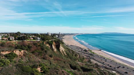 Drone-shot-revealing-Santa-Monica-Beach-and-Pier-on-a-sunny-day