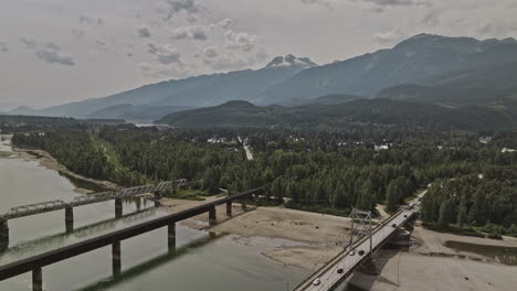 Revelstoke,-BC,-Kanada,-Luftaufnahme-V1,-Überflug-über-Den-Columbia-River,-Aufnahme-Von-Brückenübergängen-Und-Einer-Ländlichen-Landschaft-Mit-Bewaldeten-Bergen-Und-Weiten-Wildnisgebieten-–-Aufgenommen-Mit-Mavic-3-Pro-Cine-–-Juli-2023