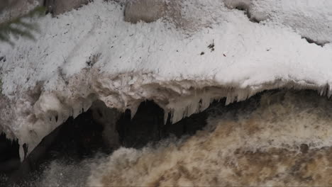 Close-up-on-winter-ice-formations-along-the-edge-of-a-swiftly-flowing-river