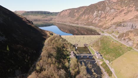 An-aerial-view-of-Caban-Coch-dam-and-reservoir-on-a-sunny-spring-day-in-the-Elan-valley,-Powys,-Wales