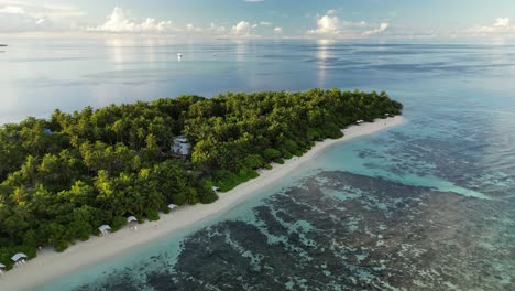 Luftaufnahmen-Einer-Drohne,-Die-Bei-Sonnenaufgang-Langsam-Entlang-Des-Bikini-Strandes-Der-Lokalen-Insel-Thinadhoo-Auf-Den-Malediven-Schwenkt-Und-Absteigt