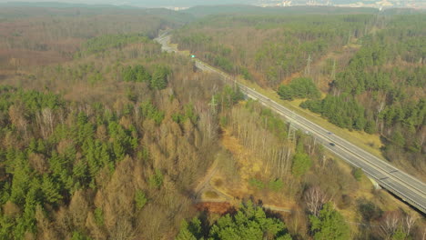 aerial-view-capturing-a-stretch-of-highway-meandering-through-a-forested-landscape