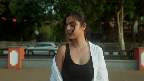 Junge-Indische-Frau-Steht-Auf-Einem-Bürgersteig-Vor-Einem-Belebten-Riad-In-Indien