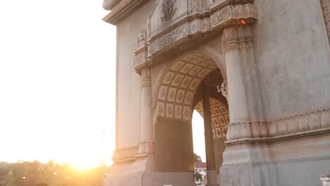 Sun-flare-behind-the-Patuxai-Victory-Monument-in-the-center-of-Vientiane,-Laos