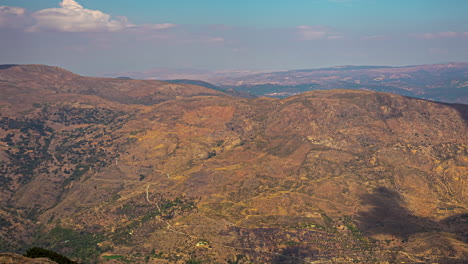 High-angle-shot-over-the-mediterranean-mountains-of-Andalusia,-Malaga,-Spain-on-a-sunny-day-with-scanty-clouds-passing-by